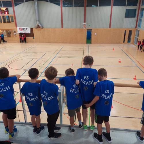 Kinder beobachten das Völkerballspiel einer anderen Mannschaft