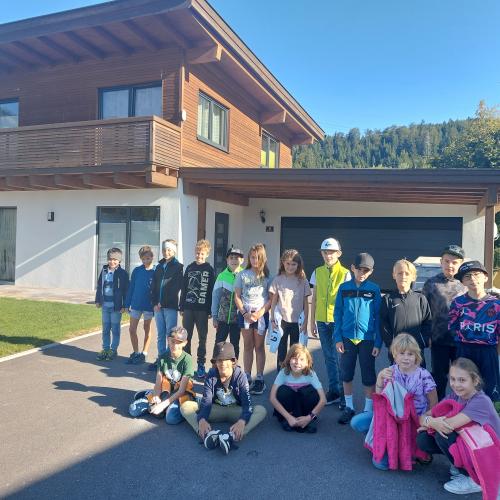 Kinder stehen vor einem Wohnhaus